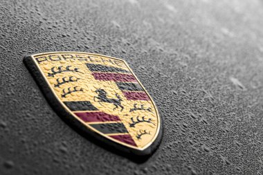 Su yağmur damlaları ile siyah bir araba Porsche logo