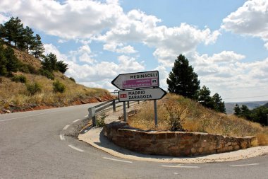 Road signs in a curve leading to Medinaceli, Madrid, or Zaragoza in Spain clipart