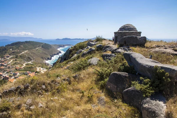 The Facho of Donon, an ancient stone lighthouse for guiding sailors in Monte do Facho, Cangas, Galicia, Spain, with Cabo Home and the Cies Islands in the background