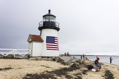 Nantucket, Massachusetts. Brant ışık, birkaç kişi Balık tutma ve Amerikan bayrağı ile liman Nantucket Adası üzerinde bulunan bir deniz feneri gelin