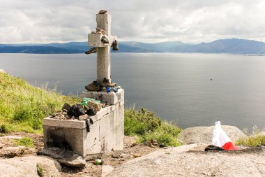 Fisterra, Spain. The cross at Cabo Finisterre (Cape Finisterre), final point of the Way of St James (Camino de Santiago) clipart