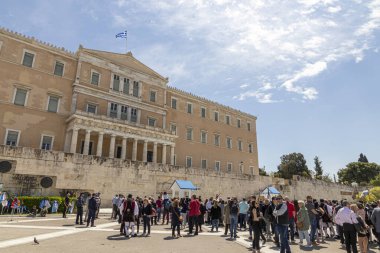Atina, Yunanistan. Eski Kraliyet Sarayı, 19. yüzyıl neoklasik binası Friedrich von Gartner, şu anda Yunan Parlamentosu 'nun merkezi, Syntagma Meydanı ile birlikte ve güneşin altında kalabalığı topladı.