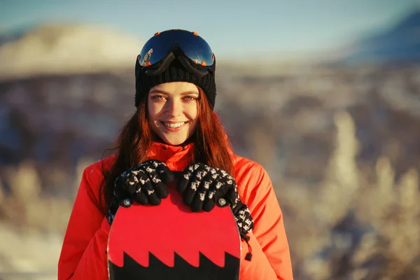 Chica con snowboard en la cima de la montaña — Foto de Stock