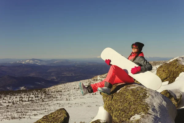 Girl with snowboard on top of the mountain — Stock Photo, Image