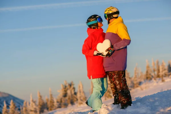 A young couple with a snowy heart in their hands against the bac — Stock Photo, Image