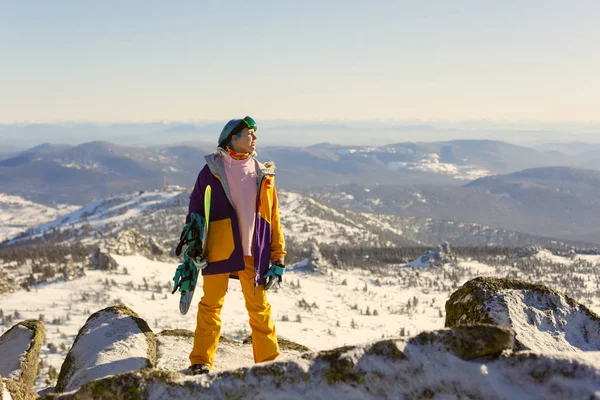 Girl with snowboard on top of the mountain — Stock Photo, Image