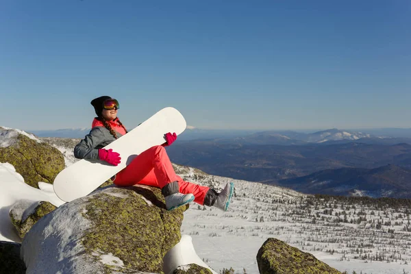 Menina com snowboard no topo da montanha — Fotografia de Stock