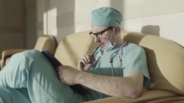 Doktor sandalyede oturuyor — Stok video
