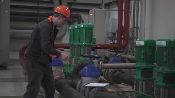 Un joven ingeniero está en una sala técnica. en la fábrica — Vídeos de Stock