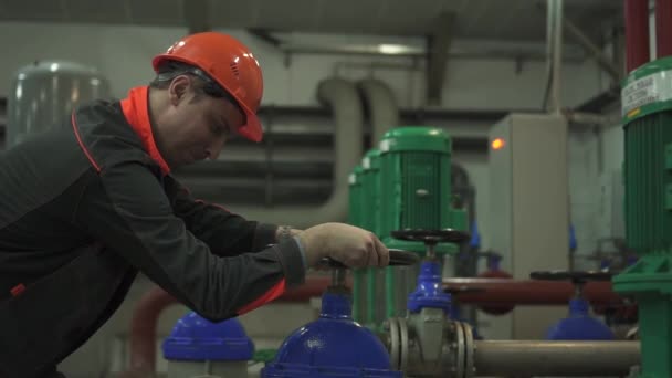 Un joven ingeniero está en una sala técnica. en la fábrica — Vídeos de Stock