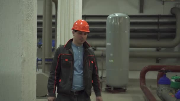 Un joven ingeniero está en una sala técnica. en la fábrica — Vídeo de stock