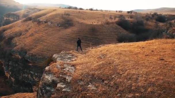 Uomo piscia sul bordo di una scogliera alta in montagna — Video Stock