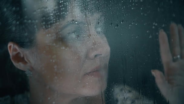 Su damlaları ile cam arkasında bir kız portresi — Stok video