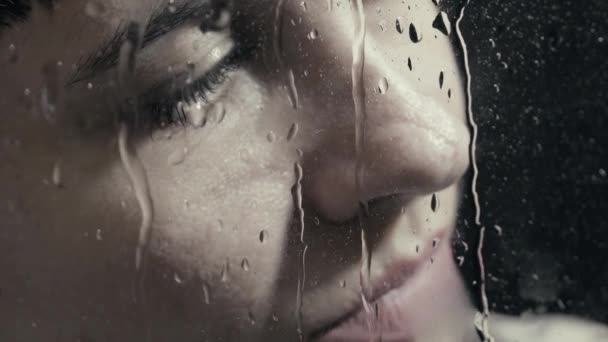 Retrato de una chica detrás del vaso con gotas de agua — Vídeo de stock