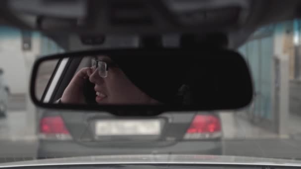 Хлопець говорить по телефону в відображенні автомобіля — стокове відео