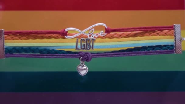 Lgbt bracelet against lgbt flag — Stock Video