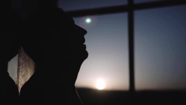 Silhouette di un ragazzo al tramonto con grande finestra — Video Stock