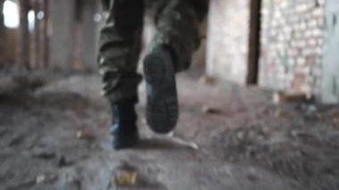 yıkılmış bir binanın koridorunda aşağı çalışan asker, askeri