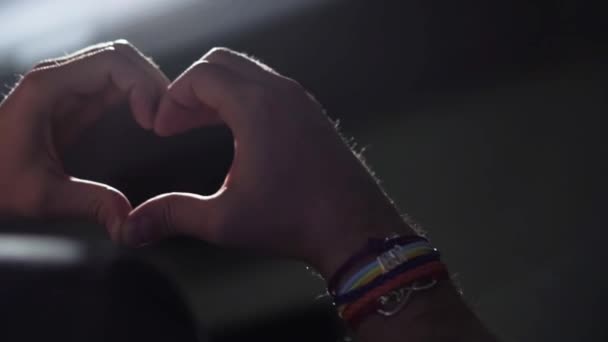 Мужчина гей показывает браслет с символом сердца — стоковое видео