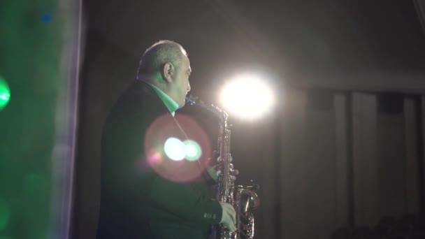 Człowiek na scenie odgrywa saksofon — Wideo stockowe