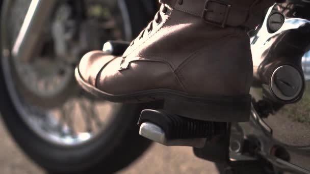En man på en motorcykel skiftar redskap — Stockvideo