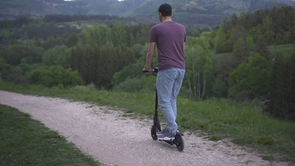 Parkta elektrikli scooter kullanan bir adam.