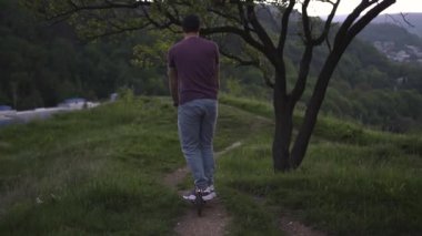 Parkta elektrikli scooter kullanan bir adam.