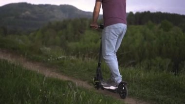Parkta elektrikli scooter kullanan bir adam.