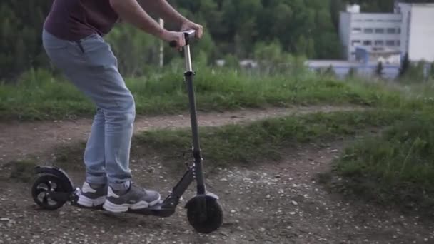 Hombre montando un scooter eléctrico en el parque — Vídeos de Stock