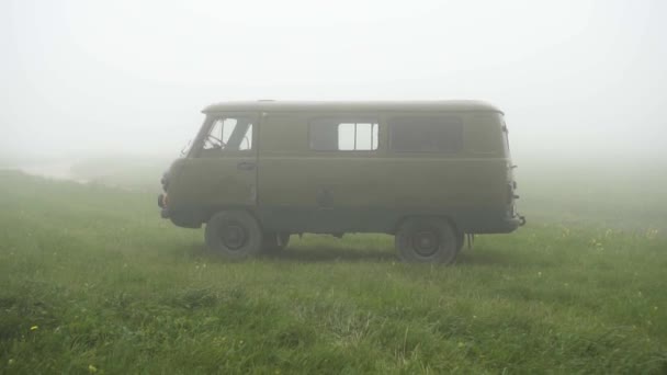 Régi szovjet katonai autó a ködben a réten — Stock videók