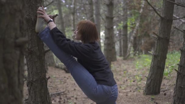 Meisje doet stretching in het wilde bos — Stockvideo