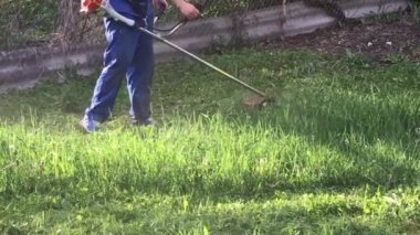 adam çiftçi doğa üzerinde bir biçme makinesi ile çim biçiyor