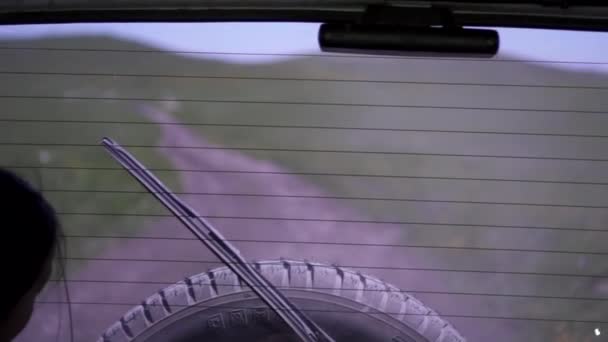 Uma jovem é levada para um SUV no porta-malas em uma estrada empoeirada — Vídeo de Stock