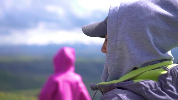 Hermosa chica asiática oliendo flores silvestres en las montañas — Vídeo de stock