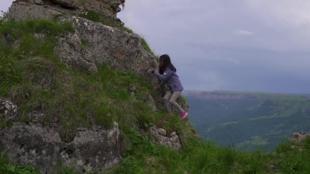 Mädchen geht an den Rand einer Klippe und öffnet ihre Arme — Stockvideo