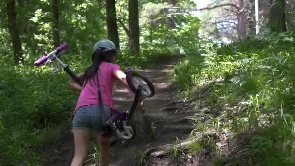 Piccola ragazza asiatica equitazione scooter nel parco, giorno — Video Stock