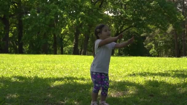 Little asian girl doing exercises in the park, day — Stock Video