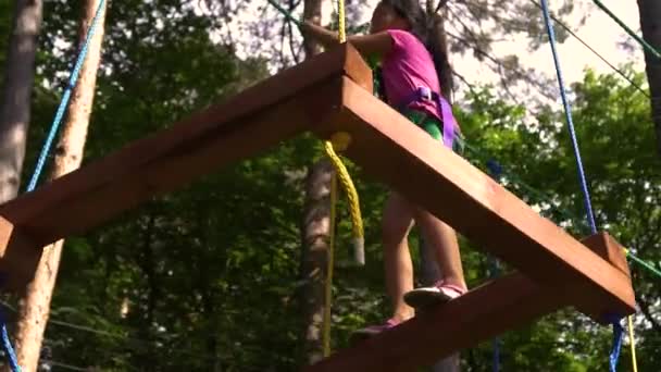 Park rozrywki, miasteczko linowe, mała Azjatycka dziewczyna przechodzi test — Wideo stockowe