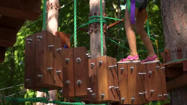 Amusement park, rope town, little asian girl passes the test — Stock Video