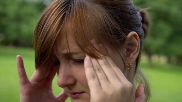 Das Mädchen in der Natur hat Kopfschmerzen — Stockvideo