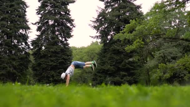Chico haciendo volteretas en la naturaleza — Vídeos de Stock