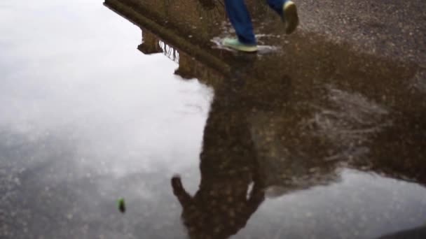 水たまりの中で反射を踏んだ女性 — ストック動画