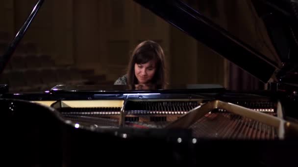 Девушка играет на пианино в концертном зале — стоковое видео
