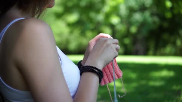 Jeune fille faisant du tricot dans le parc sous un arbre — Video