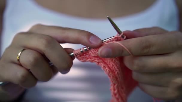 Young girl doing knitting in the park under a tree — Stock Video