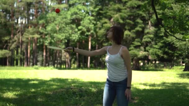 Mädchen schlägt Schläger auf Ball im Park — Stockvideo