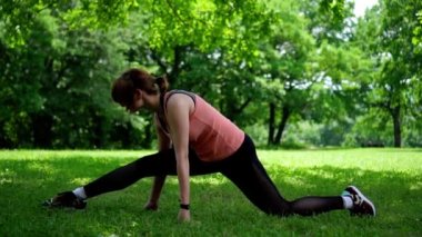 Kız parkta çim üzerinde bir ikine oturur