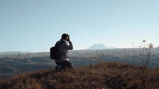 Человек делает фото в горах — стоковое видео