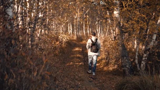 El tipo está caminando en el bosque de otoño — Vídeos de Stock