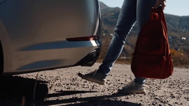 Meisje opent auto kofferbak met benen gebaar — Stockvideo